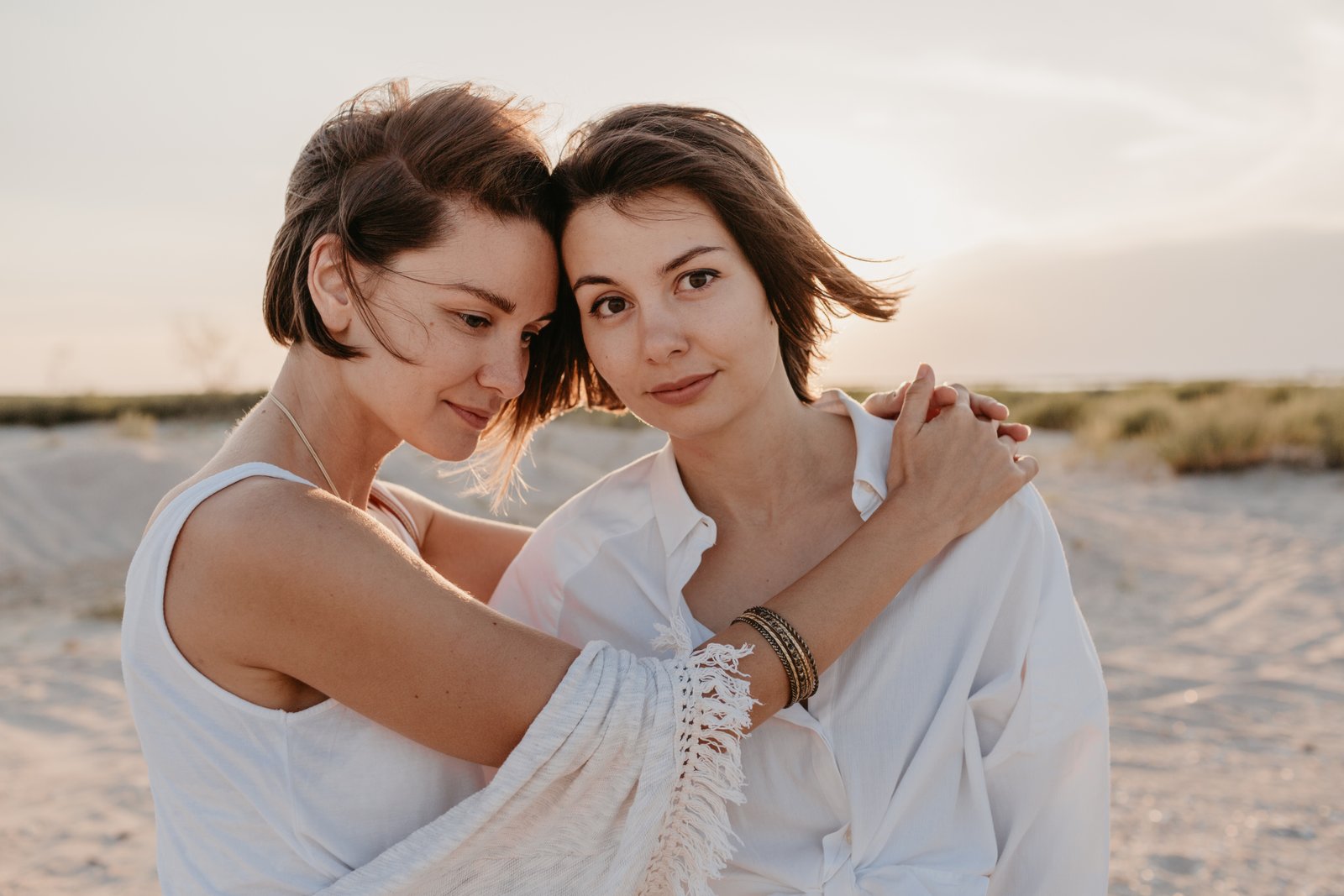 Two women sharing a close moment on a beach